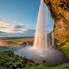 Colors seem to dance as the soft light warms the waterfall Seljalandsfoss in the Southern Icelandic Countryside.